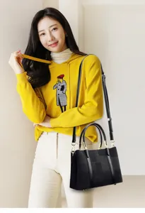Detailed view of the elegant black commuter tote bag showcasing high-end gold hardware.