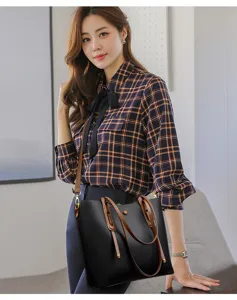 Detailed view of the stylish large-capacity black tote bag with brown handles and strap.