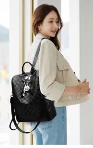 Vista detallada de mochila de cuero negro a cuadros, elegante bolso de día para mujeres.