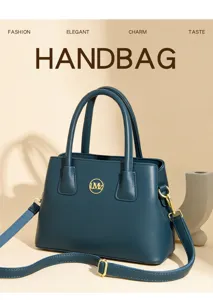 Detailed view of dark blue leather handbag, featuring gold hardware, top handles, and strap.