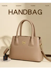 Detailed view of elegant taupe handbag with gold hardware, chic top handles and crossbody strap.