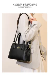 Close-up detail view of the black leather women tote bag with metal logo and shoulder strap.