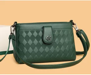 Elegant dark green diamond quilted leather crossbody bag with chic clover clasp detail