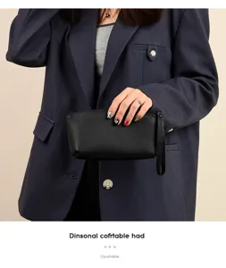 Vue détaillée d'une pochette poignet en cuir de vachette noir, design compact et portable.