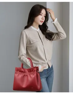 Stylish red leather drawstring tote bag with top handle for women commuting and daily shopping.