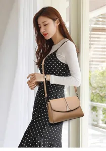 Detailed view of women's PU leather shoulder bag with chic metal buckle and fine strap.