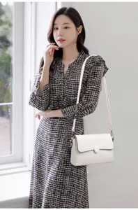 Stylish white shoulder bag detail showing premium leather texture, elegant clasp and strap.