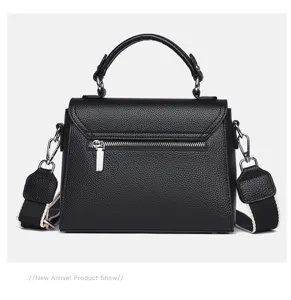 Black genuine leather top handle handbag detail showing zipper and woven strap texture.