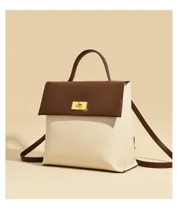 Close-up detail shot of the two-tone leather women backpack with brown flap and gold lock.