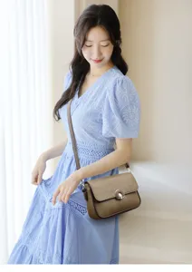 Detailed view of the stylish brown leather crossbody bag worn by model in detail.