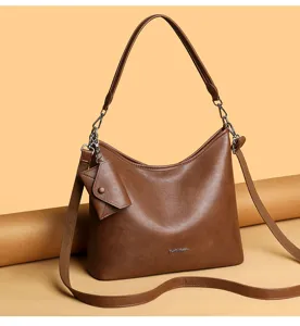 Detail view of stylish brown women hobo shoulder bag with small coin pouch and hardware.