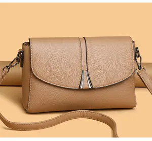 Detailed view of women khaki leather shoulder bag, elegant flap design with metal decor.