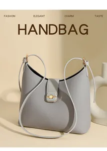 Grey leather bucket bag detail showing fine texture, elegant metal lock clasp and strap.