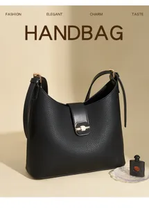 Black leather handbag detail, exquisite gold hardware lock and pebbled texture surface.