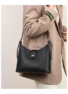 Detail view of the elegant black leather bucket bag featuring gold-tone lock hardware.