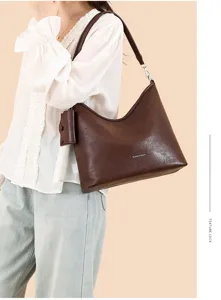 Detail view of the elegant brown shoulder bag, showing smooth leather texture and neat stitching.