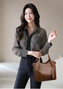 Large capacity soft leather tote bag with stylish commuter design, shown in detail use.