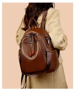 Stylish women's brown soft leather backpack with multi-zipper compartments and chic bead charms.