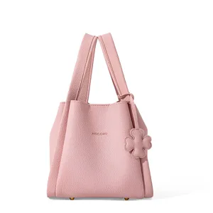 Pink leather bucket bag for women, stylish minimalist tote with clover charm and sturdy handles.