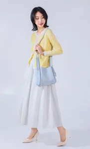 Elegant light blue bucket bag with double handles, stylish minimalist design for women.