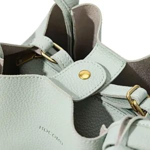 Detailed close-up view of the light green leather bucket bag showcasing fine hardware.