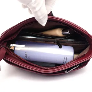 Wine red soft leather shoulder bag with spacious interior compartment and zip pocket.
