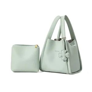 Green leather bucket bag detail view, minimalist style with clover charm and matching pouch.
