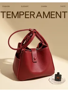 Détail de sac seau en cuir souple rouge vin, sac à épaule texturé pour femmes déplacement.