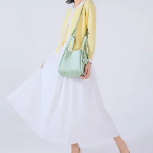 Stylish women leather bucket bag with top handles and clover charm, perfect for daily wear.