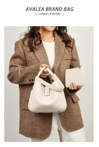 Vue détaillée du sac seau en cuir souple motif litchi, texture fine et belles finitions métalliques.