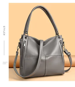 Grey leather shoulder bag for women, stylish tote handbag with top handles and zipper design.