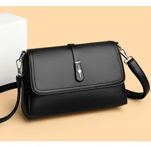 Close-up detail of stylish black leather small shoulder bag with chic metal hardware design.