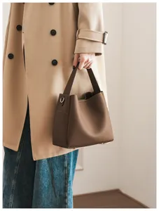 Stylish brown soft leather bucket bag for women, featuring a chic top handle and interior.