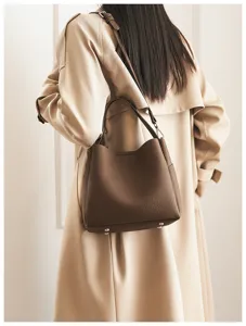 Detailed view of the brown soft leather bucket bag worn, showing texture and stylish design.