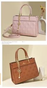Close-up details of stylish quilted leather tote bag with elegant golden hardware charm.