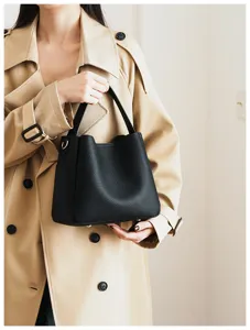 Detail shot of black soft leather bucket bag, elegant handbag with top handle for women.