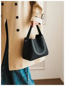 Detail shot of black soft leather bucket bag with metal D-ring and handle, versatile style.