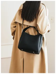 Black soft leather bucket bag detail, versatile shoulder crossbody design with metal feet.