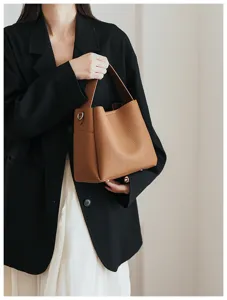 Close-up detail of the brown soft leather bucket bag showcasing premium pebbled texture.