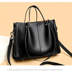 Stylish black leather tote bag for women, spacious commuter handbag with wide shoulder strap.