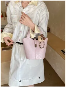 Graziosa borsa a secchiello rosa in pelle da donna con ciondolo a orsetto, borsa chic a tracolla.