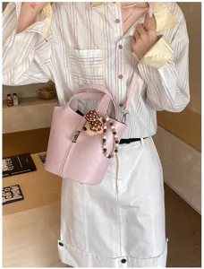 Vista dettagliata borsa a secchiello in pelle PU rosa con simpatico orsetto e tracolla regolabile.