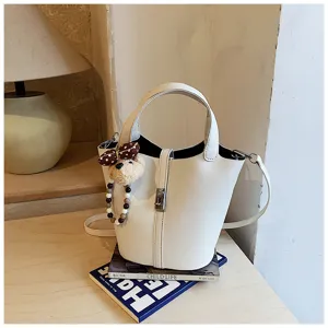 Borsa a secchiello bianca chic in pelle con ciondolo orsetto, elegante borsa a tracolla donna.