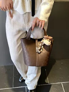 Borsa a secchiello marrone da donna con simpatico ciondolo a forma di orsetto e serratura, elegante