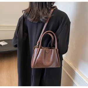 Detailed view of the soft PU leather brown handbag showing texture and shoulder strap design.