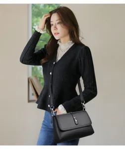 Detailed view of the elegant black leather shoulder bag showcasing refined metal hardware and clasp.