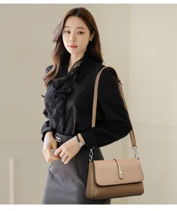 Elegant brown shoulder bag detail showcasing sleek textured leather and metal clasp design.