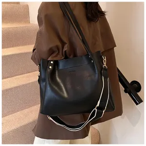 Detailed view of women's black PU leather shoulder bag with contrast strap and metal hardware.