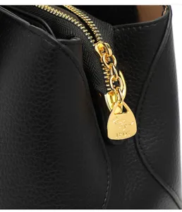 Detailed view of the luxury black lychee leather handbag gold zipper hardware close-up.