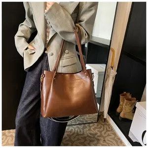 Stylish brown leather tote bag for women, large capacity casual shoulder bag daily wear detail.